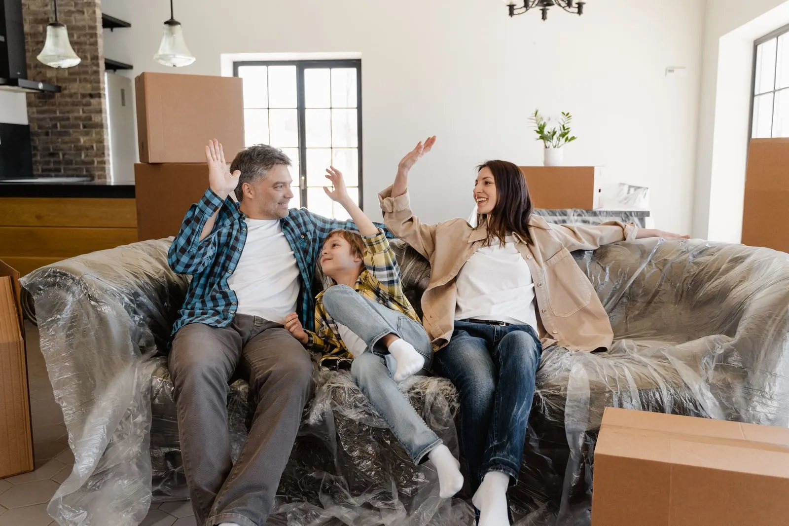 Familie freut sich in ihrem neuen Zuhause zwischen Umzugskartons